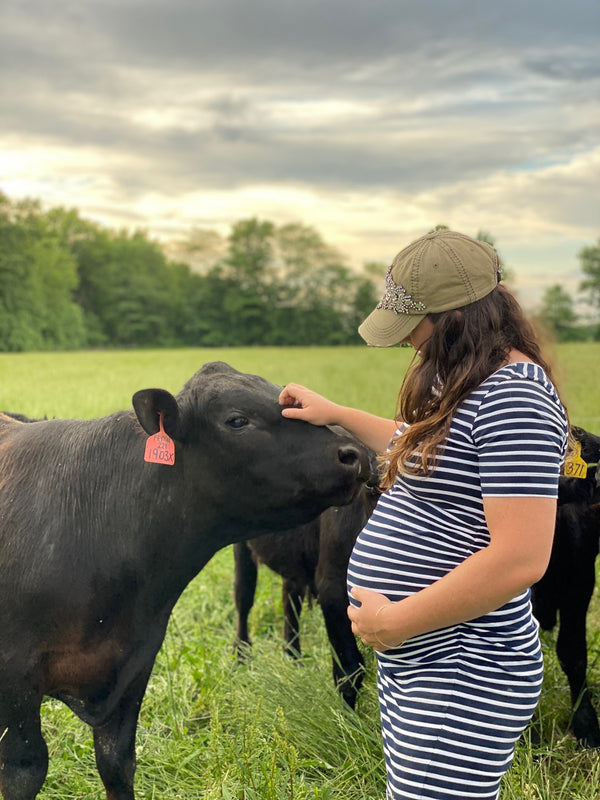 Pregnant farmer with cows 